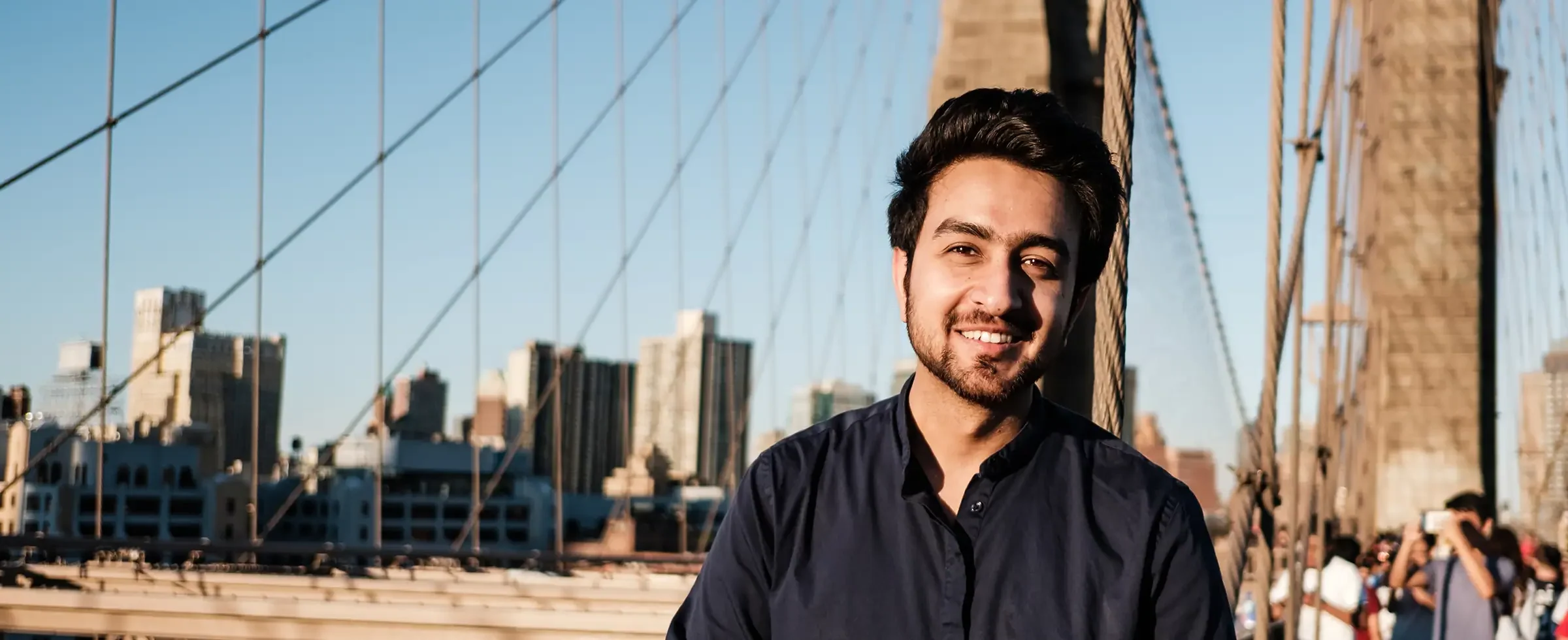 Pakistani man smiling on bridge in NY