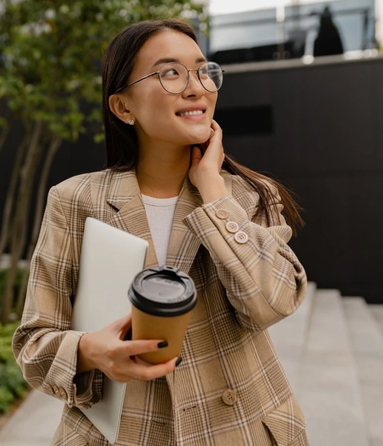 young woman wearing glasses and grabbing a coffee