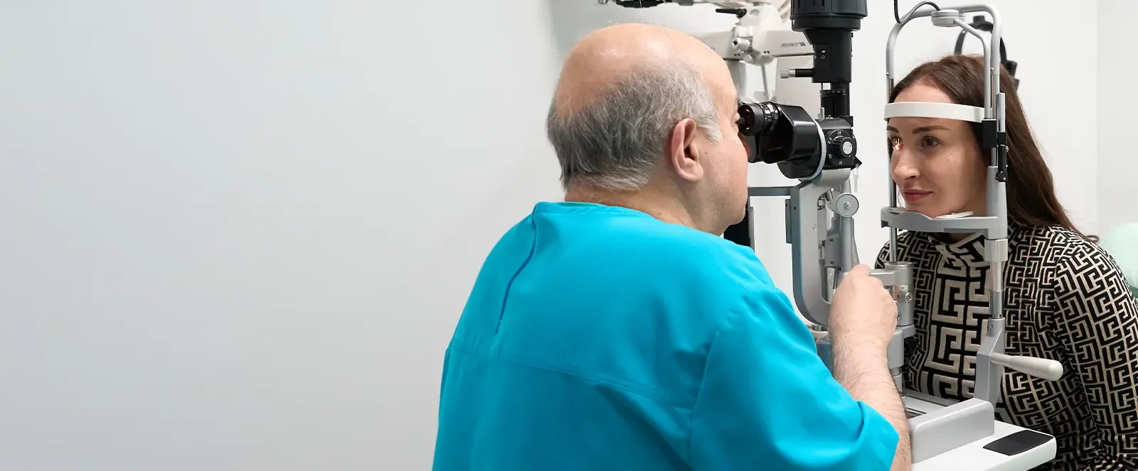dr khosrof examining a patients eyes-banner