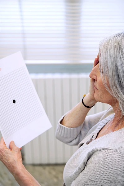 woman testing herself for macular degeneration at home looking at amsler grid